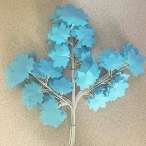 Artificial blue maple leaf branch decoration, detail shot showing dense foliage and stems.