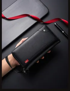 Detail view of men's black leather long wallet with wrist strap and card slots for business use.