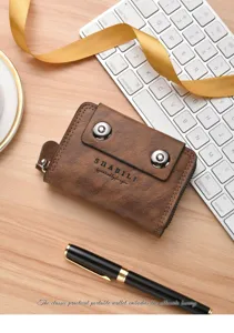 Detail shot of a vintage brown leather accordion card holder with double magnetic snap buttons.