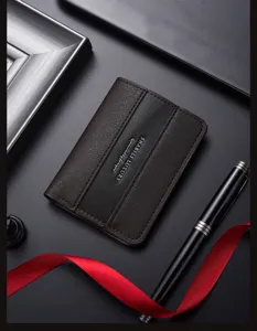 Detailed view of the dark brown leather card holder featuring texture and a sleek metal pen.