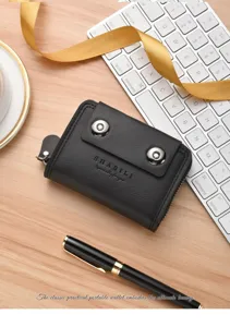 Detail view of black leather accordion card holder with dual magnetic button closure on desk.