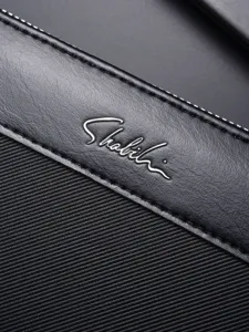 Borsa a mano da uomo in ecopelle nera dettaglio con logo metallico in corsivo e cuciture accurate.