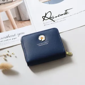 Detail view of the dark blue short wallet with white daisy flower and gold zipper.