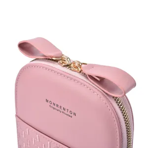 Detailed view of the pink crossbody phone bag featuring a zipper and woven pocket design.