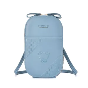 Close-up detail of the light blue leather crossbody phone bag with cute bow and bear embroidery.