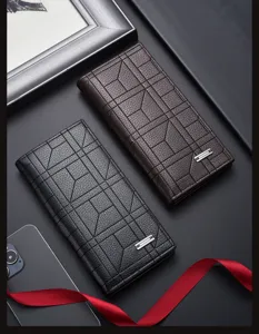 Détail portefeuille long homme, cuir texturé de qualité avec motif géométrique élégant.