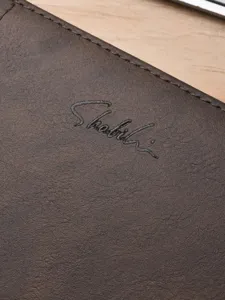 Portefeuille long en cuir marron pour homme, élégant et pratique avec logo en relief.