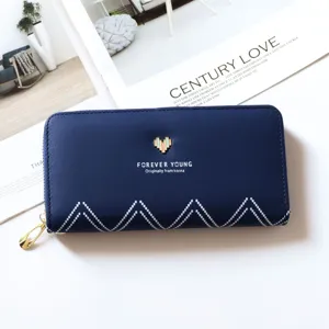 Detailed view of a stylish blue long wallet with a heart metal decor and secure zip.