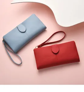 Detail shot of women's solid color long wallet featuring wrist strap and zipper closure.