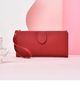 Red long wallet detail view showing the elegant solid color leather design and wrist strap.