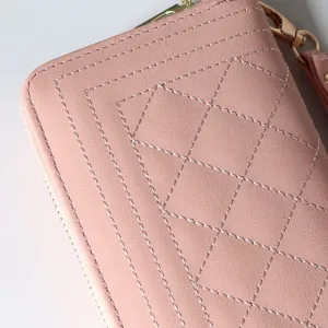 Pink long quilted zip wallet for women with elegant diamond stitching and wrist strap detail.