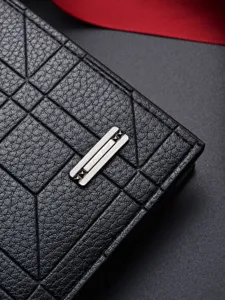 Portefeuille long classique pour homme en cuir noir avec motif élégant et badge métallique.
