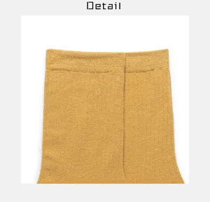 Nahaufnahme der Detailansicht von senfgelben Stricksocken-Bündchen mit feiner Rippstruktur.