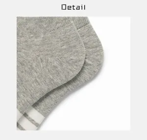 Close-up of grey and white striped cotton boat socks, soft and breathable fabric detail.
