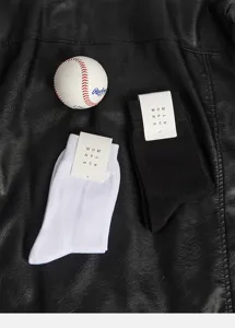 Detailed view of men's solid color cotton mid-tube socks in black and white, cozy and breathable.