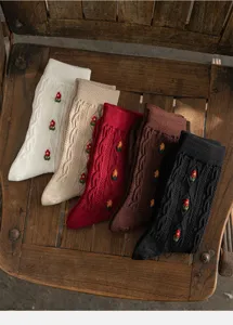 Detailed view of cozy knit cotton socks with cable pattern and floral embroidery in multiple colors.