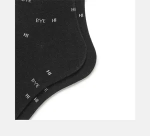 Close-up detail of black cotton crew socks with white letter prints, stylish casual socks.