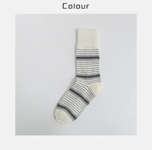 Detail view of black and white striped cotton mid-tube socks, featuring ribbed cuff design.
