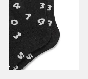 Close up of black casual crew socks featuring trendy white digital pattern knit details.