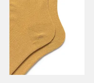 Nahaufnahme von senfgelben Rippstrick-Baumwollsocken für Damen, feine Texturansicht.