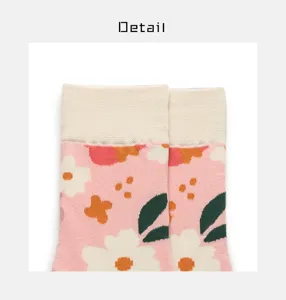 Pink floral cotton crew socks detail shot showing daisy print and ribbed cuff texture.