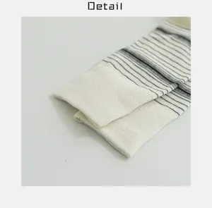 Detailed view of white and black striped cotton socks, highlighting knit texture and ribbed cuff.