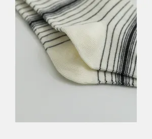 Close-up detail of black and white striped cotton socks fabric texture, minimalist view.