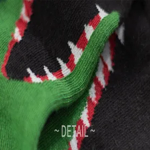 Close-up knit sock detail showcasing colorful monster teeth pattern, soft cotton fabric texture.