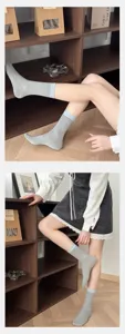 Grey mid-calf women socks with blue cuffs, cozy knit texture, detailed lifestyle shot.