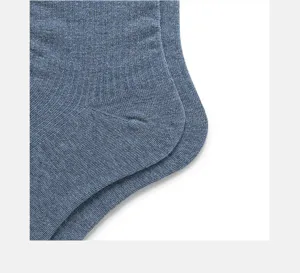 Close-up detail of grey-blue knitted socks heel, showing soft texture and fine weaving craftsmanship.