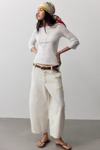 Detailansicht lässiger, weiter Damen-Jeanshosen mit weitem Bein, kombiniert mit weißem Top.