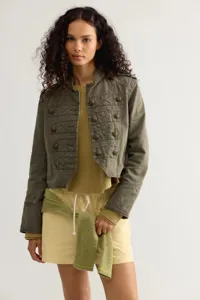 Detail shot of women's military cropped jacket featuring ornate metal buttons and braided trim.