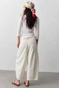 Detailansicht der lässigen weiten Hose in Offwhite, zeigt Nähte und Taschen im Rückenbereich.