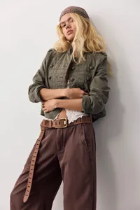Close-up detail of the stylish olive green crop jacket and belt combination worn by model.