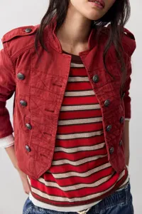 Detailed shot of women red cropped military jacket with vintage metal buttons and striped top.