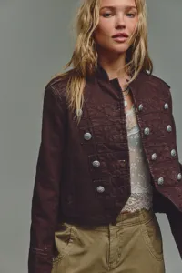 Detailed shot of women's vintage military crop jacket with double-breasted silver metal buttons.