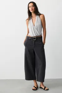 Detailansicht von lässigen Damen-Weitbein-Jeans kombiniert mit einem grauen Oberteil.