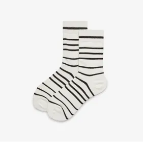 Close-up detail shot of white cotton crew socks featuring classic black horizontal stripes design.