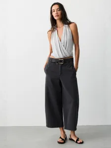 Damen Vintage lose lässige weite Jeans kombiniert mit einem stylischen grauen Neckholder-Top.