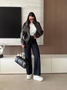 Detailed view of the stylish contrast stitching denim wide-leg pants and jacket outfit.