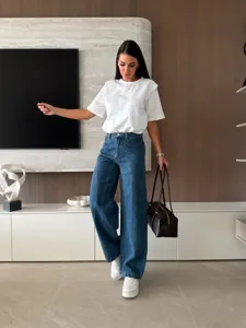 Stylish casual women outfit detail featuring a white t-shirt and wide leg blue jeans.