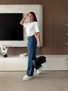 Detailed view of casual women outfit featuring a white t-shirt and denim wide leg pants.