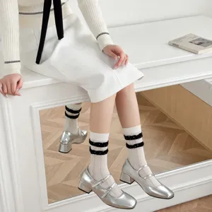 White mid-calf socks with polka dot ruffles paired with stylish silver Mary Jane low heels.