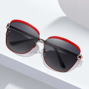 Modelli occhiali da sole oversize da donna in metallo con montatura rossa e lenti scure.