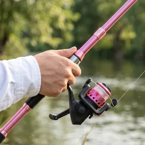 Pink telescopic fishing rod and spinning reel combo close-up detail for outdoor angling.