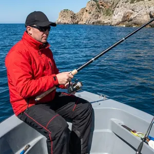 Gedetailleerd overzicht van een draagbare telescoophengst met vismolen in actie op boot.