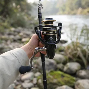 Detailed closeup of a carbon fishing rod and spinning reel in an outdoor river setting.