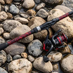 Close-up of the telescopic fishing rod and spinning reel set displayed on river stones.