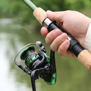 Detailed close-up of portable telescopic fishing rod with reel and comfortable cork handle.