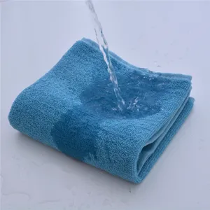 Detailed shot of thick blue cotton bath towel showing water absorption and fabric texture.